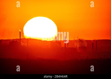 Setting sun, in front chimneys and gasometer of the coking plant Prosper in Bottrop, Stock Photo