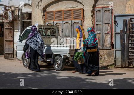 Destination Tanzania, Zanzibar Island: Impressions from Stone Town, the oldest part of Zanzibar City, the capital of the Tanzanian state of Zanzibar at the end of Ramadan. Three veiled local women shopping. Stock Photo