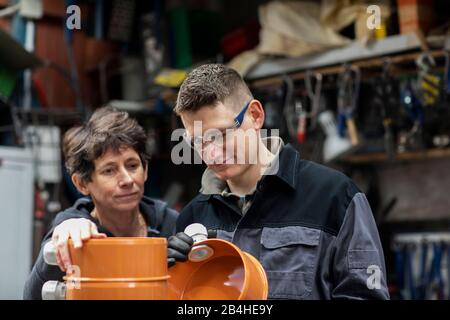 Plumber maleand Leader woman  working in a workshop Stock Photo