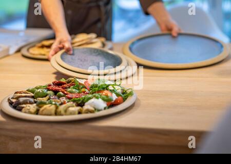 round antipasti plate on modern wooden dining table Stock Photo