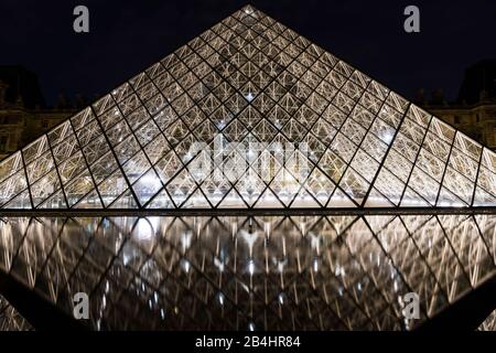 Glass pyramid illuminated at night in the Louvre reflected in the water, Paris, France, Europe Stock Photo