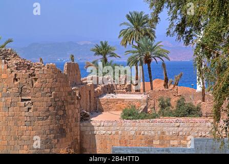 Historical ruins of the fort with date palms by the sea. Akaba Aqaba, Gulf of Aqaba, Red Sea, Jordan Stock Photo