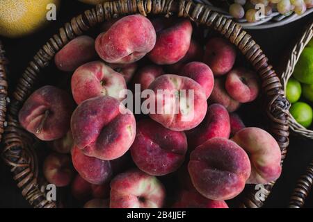 flat Peaches in basket for sale, close-up Stock Photo