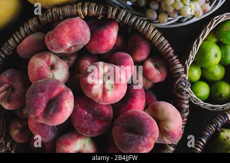 flat Peaches in basket for sale, close-up Stock Photo