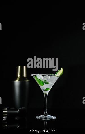 A cocktail glass with ice vodka, peppermint leaves and a slice of lime Stock Photo