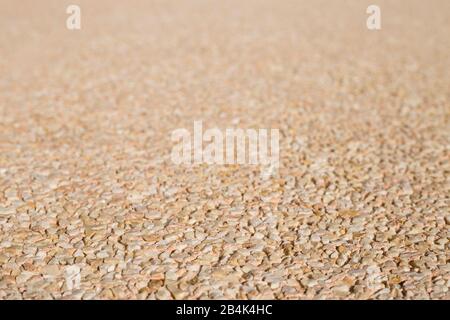 selective stucco wall focus with small stones and beige tones Stock Photo