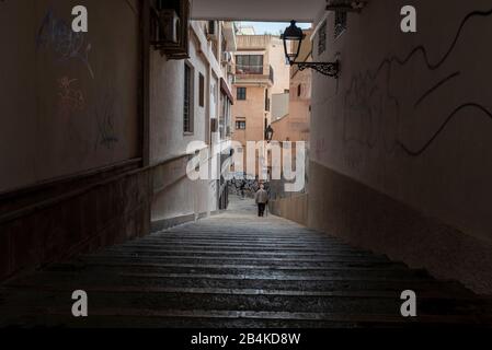 Spain, Mallorca, Palma, a man with cane is walking down a staircase. Stock Photo