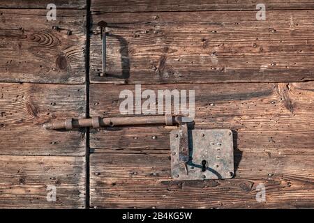 Wooden vintage door with latch rusted lock, Agordino, Dolomites, Agordo, Belluno, Veneto, Italy Stock Photo