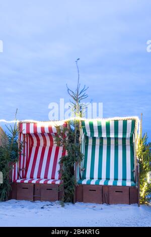 Deutschland, Mecklenburg-Vorpommern, Wustrow, Strandkörbe, Weihnachtsmarkt am Strand, Tannengrün, blaue Stunde. Stock Photo