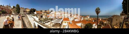 Europe, Portugal, capital city, old town of Lisbon, panoramic shot, viewpoint, Miradouro de Santa Luzia, view over the Alfama district and the bay of the Rio Tejo, tourists with selfies Stock Photo