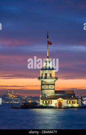 Maiden's Tower in Istanbul, Turkey at night with a mosque and Galata tower in the background Stock Photo