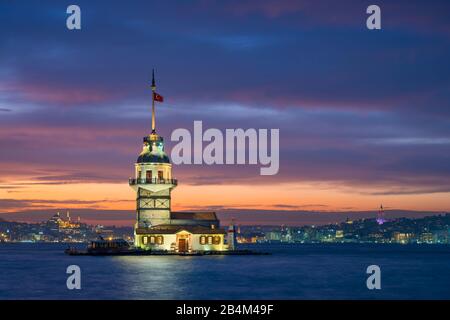 Maiden's Tower in Istanbul, Turkey at night with a mosque and Galata tower in the background Stock Photo