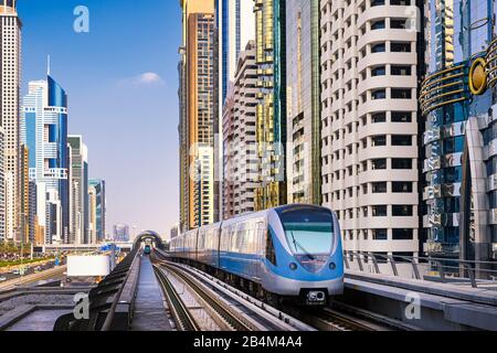 Metro train among skyscrapers of Sheikh Zayed Road in Dubai, UAE