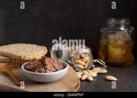 Homemade vegan chocolate spread in a small bowl made of almond butter,cacao and honey. Stock Photo