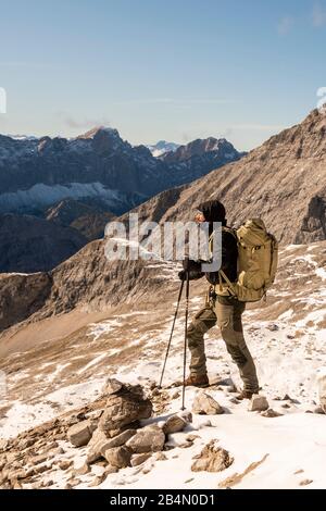 Mountaineer with a large backpack and sticks in the high mountains of the Karwendel Stock Photo