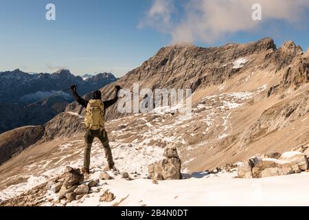 Mountaineer with a large backpack and sticks in the high mountains of the Karwendel Stock Photo