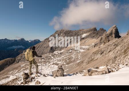 Mountaineer with a large backpack and sticks in the high mountains of the Karwendel Stock Photo