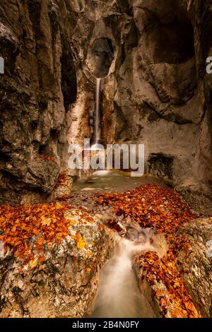 A small stream on the Kesselberg near Kochel am See with a breakthrough in the rock and waterfall in autumn. Stock Photo