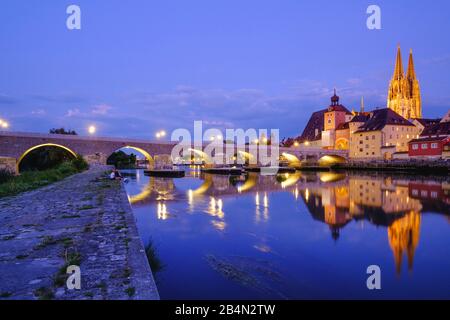 Stone bridge over Danube and old town with cathedral at dusk, Regensburg, Upper Palatinate, Bavaria, Germany