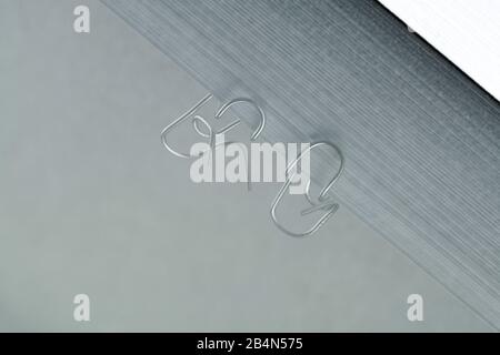 Paper clips are having a conversation, reflection Stock Photo