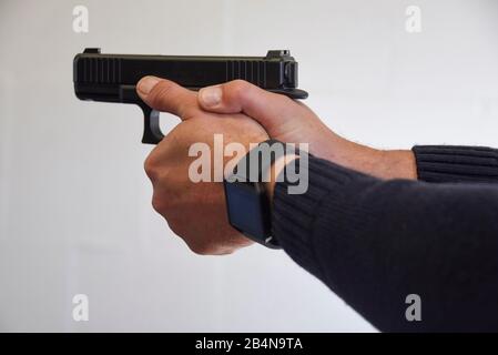 A police officer aims at a shooting range with a 'Glock 46' pistol. Stock Photo