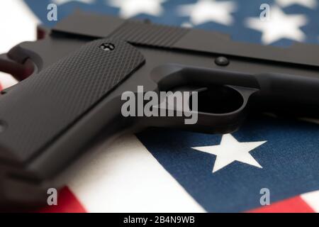 Semi-automatic pistol lying on American flag. Concept of American gun culture, the second amendment and right to bear arms in the USA. Stock Photo
