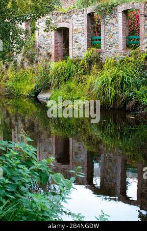 Dry stone wall on the river with door and window caves. Pontrieux is a commune in the Brittany region in the Côtes-d'Armor department in the canton of Bégard. It lies on the banks of the Trieux river Stock Photo