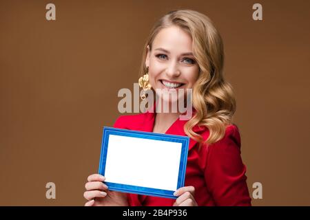 Smiling pretty lady with blank card posing in studio Stock Photo