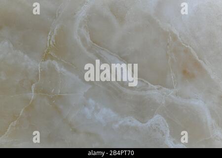 Natural beige polished marble with diagonal wavy lines. Stock Photo