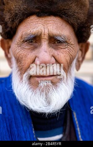 Uzbek man wearing a fur hat and traditional clothes, Uzbekistan, Bukhara Stock Photo