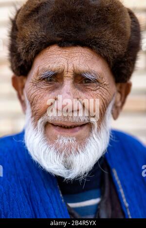 Uzbek man wearing a fur hat and traditional clothes, Uzbekistan, Bukhara Stock Photo