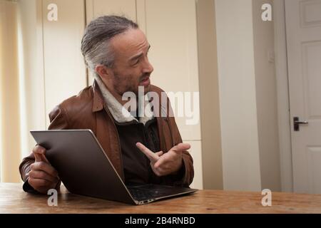 A man showing something on his laptop screen to another Stock Photo