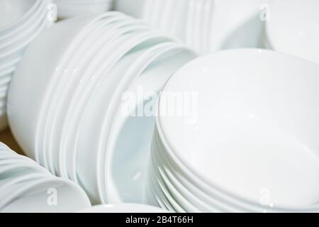 Modern folded white plates in piles. Close up. Stock Photo