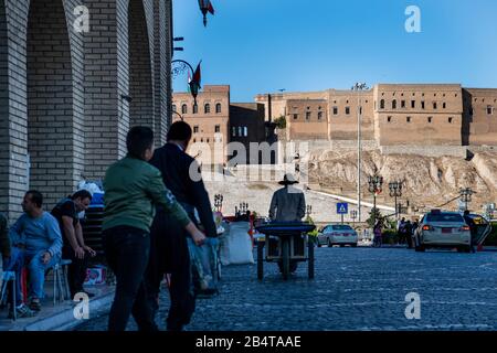 Iraq, Iraqi Kurdistan, Arbil, Erbil. Next to the the park Shar  on the right and the bazar on the left, men are sitting down under the archs. Stock Photo