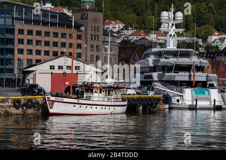 The small charter vessel Weller (built 1947), a veteran Twin Screw Motor Yacht, Dickens class. Moored at Bradbenken quay in Bergen, Norway. In backgro Stock Photo