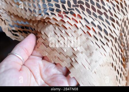 Examine the packaging. Touch the thin brown paper into the grid. New type of packaging. Stock Photo