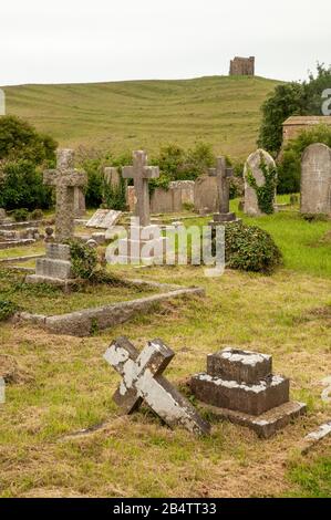 View to St Catherine's Chapel on a hilltop in Abbotsbury seen from St Nicholas church's graveyard with gravestones, Dorset, England. Stock Photo