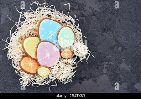 Easter card with gingerbread cookies. Easter spring decorative composition with nest and gingerbread cookies in form of eggs on blue background. Stock Photo