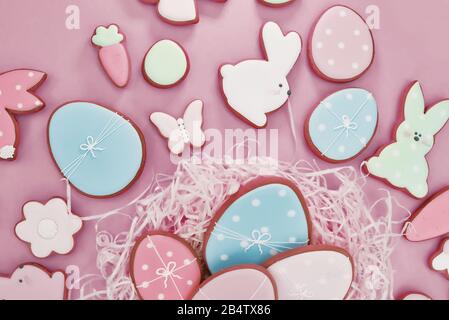 Easter card with gingerbread cookies. Easter spring decorative composition with homemade Easter cookies in form of funny rabbit and eggs on pink Stock Photo
