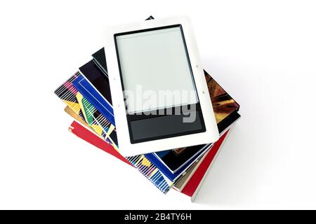 E-book reader in pink case on a pile of old books Stock Photo