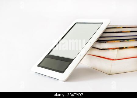 E-book reader in pink case on a pile of old books Stock Photo