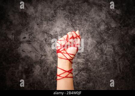 Women hand-tied with rope, the idea of freedom expression on dark grunge background in low key. international human rights day concept. Stock Photo