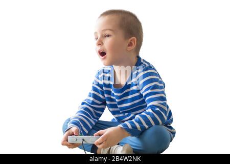 Cute boy sitting on bed while playing with tablet Stock Photo
