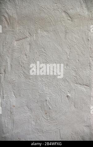Roughly treated white putty wall with furrows. Texture wallpaper. Stock Photo