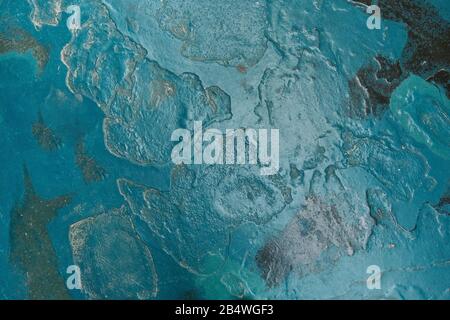 Stone wall painted in turquoise color with gray stains Stock Photo