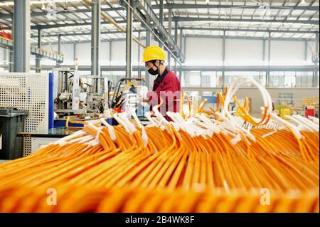 Chinese workers manufacture integrated electric motors at the plant of CCS Electric in Qingdao City, east China's Shandong Province on March 2nd, 2020 Stock Photo