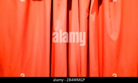 Red curtain use for background. Silk Cloth Background, Red Satin Fabric Waves, Abstract Texture. Red concert curtain full of folds. Stock Photo