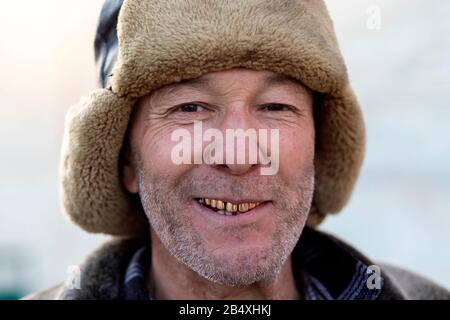 Portrait of friendly Uzbek salesman with fur hat and golden teeth, Bukhara, Uzbekistan Stock Photo