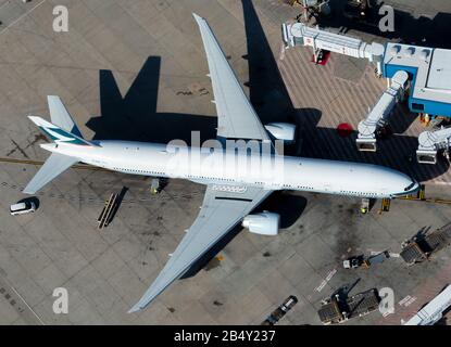 Aerial view of Cathay Pacific Airlines widebody Boeing 777 parked at international airport terminal jet bridge. Sydney, Australia. Stock Photo