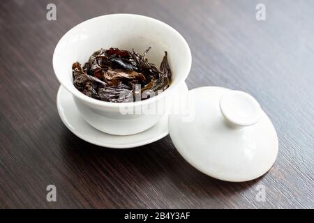 Chinese porcelain yuan zhu hu type for tea ceremony or gong fu cha or kung fu tea for brewing oolong, on wooden table or chaban Stock Photo